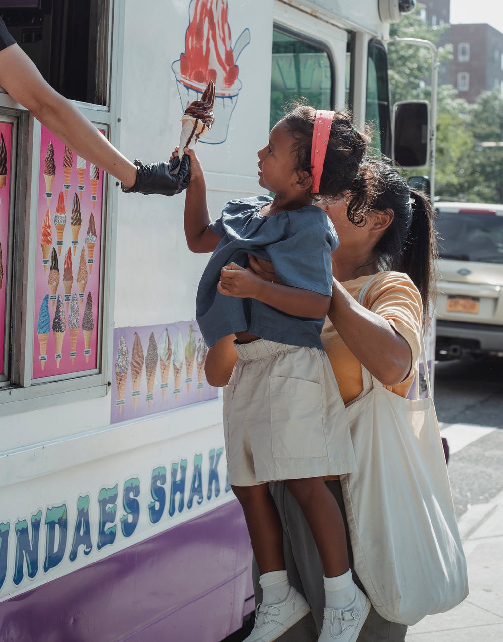 ethnic woman buying ice cream with daughter