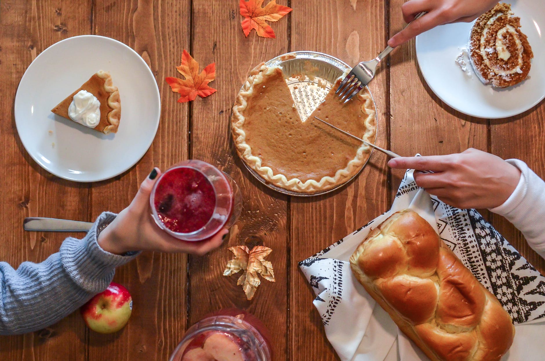 slicing of pumpkin pie placed on wooden surface